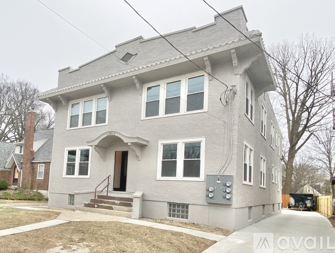 A grey house with a brown door and windows.