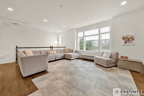 A spacious living room with a large rug, a sofa set, and a coffee table.