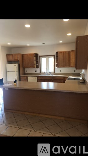 A kitchen with brown cabinets and a white fridge.