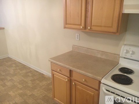 A kitchen with wooden cabinets and a white stove.