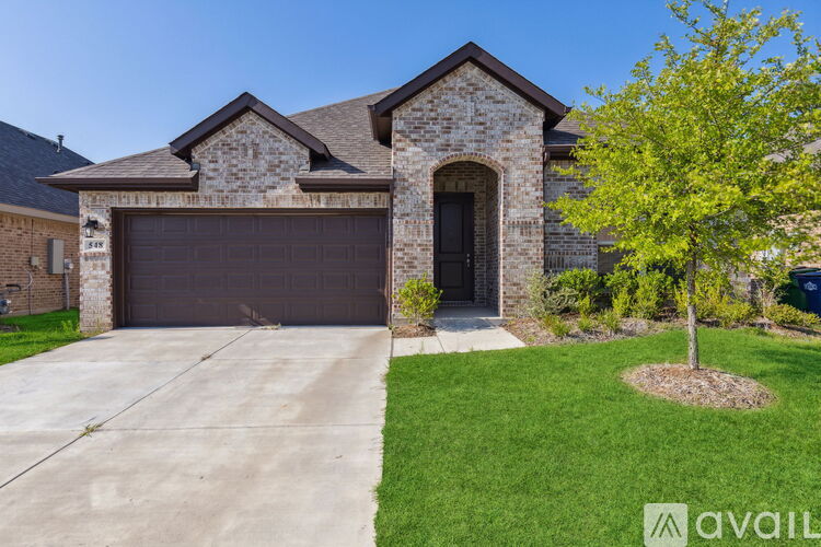A house with a brown garage door and a tree in front.