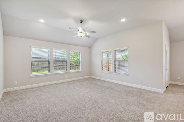 A spacious room with a ceiling fan and carpeted floor.