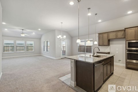 A spacious kitchen with a center island and pendant lights.