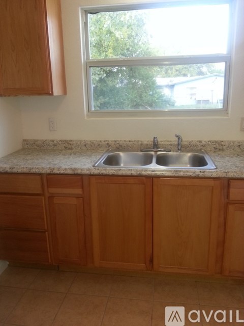 A kitchen with wooden cabinets and a granite countertop.