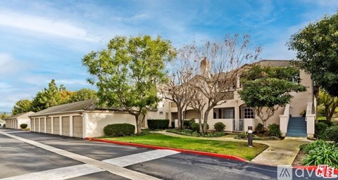 A row of houses with trees in front of them.