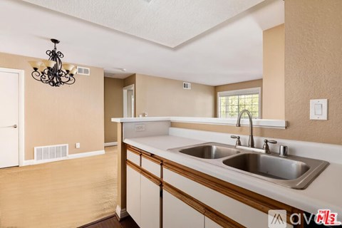A kitchen with a sink and a chandelier.