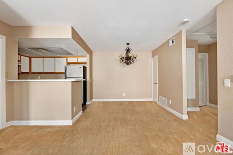 A room with wooden flooring and a chandelier hanging from the ceiling.