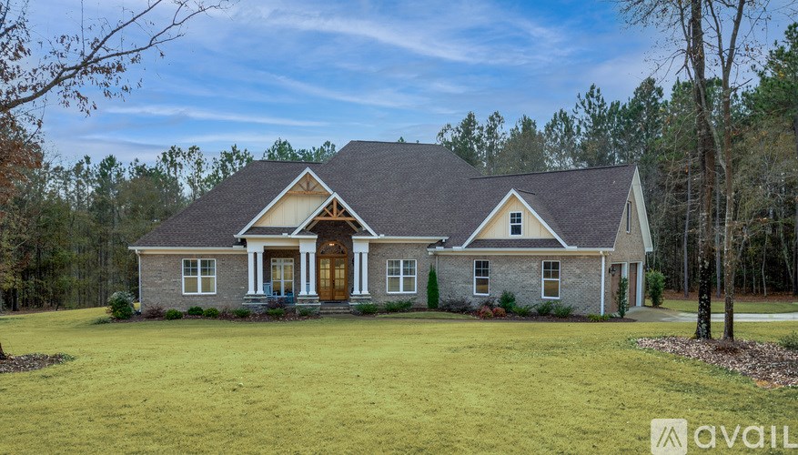 A house with a front yard and a tree in the front.