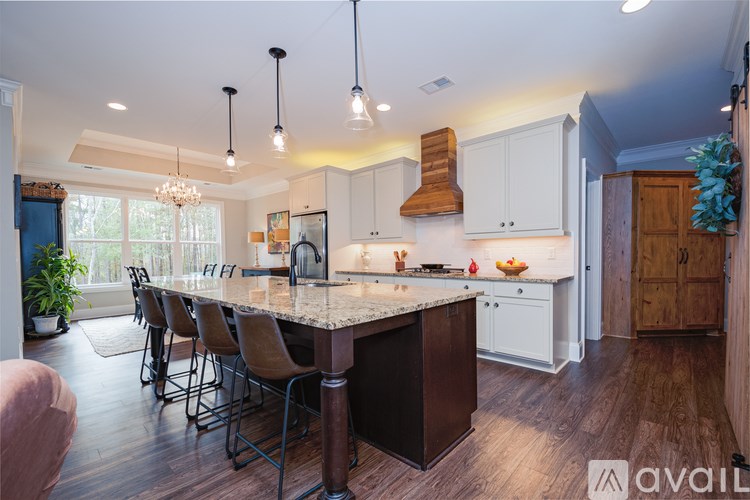 A kitchen with a large island and chairs.