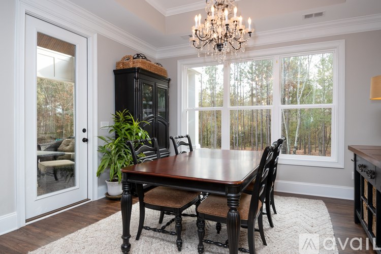 A dining room with a wooden table and chairs.