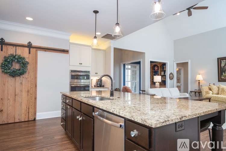A kitchen with a granite countertop and a wreath hanging on the door.