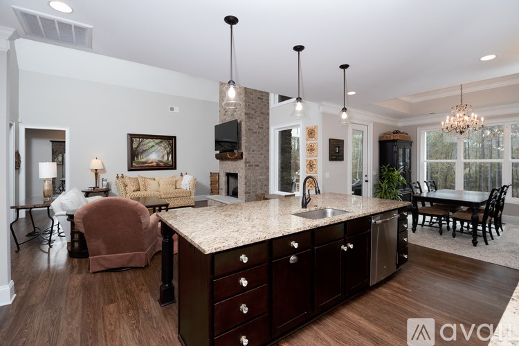 A modern kitchen with dark wood floors and a large island.