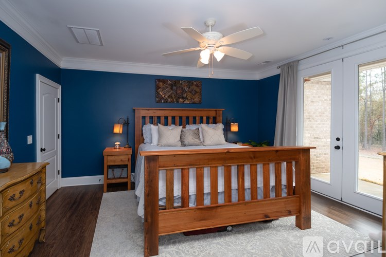 A bedroom with a bed, dresser, and ceiling fan.