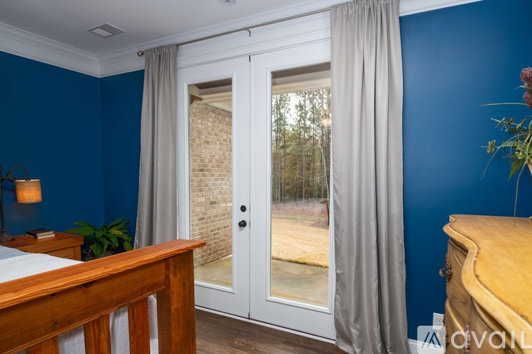 A bedroom with blue walls and a wooden bed frame.