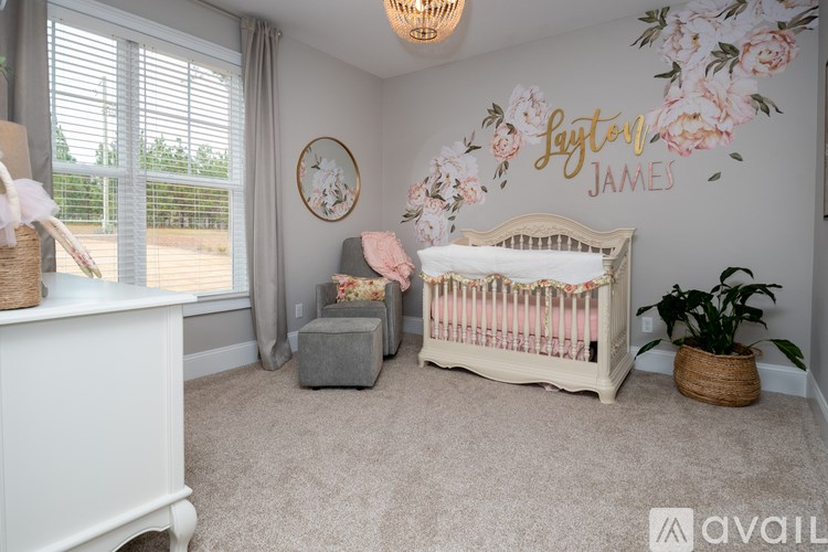 A baby nursery with a white crib and a floral wall decal.