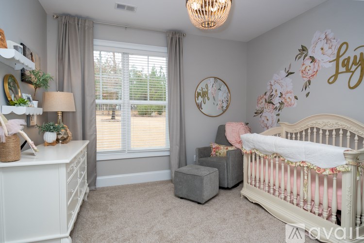 A nursery room with a crib, a dresser, and a window with blinds.