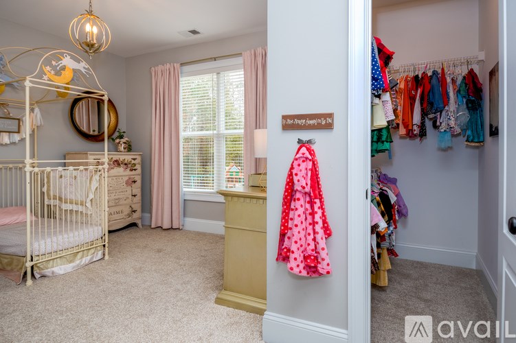 A baby's room with a crib, a dresser, and a closet full of clothes.