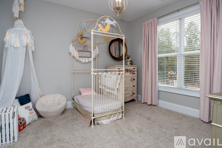 A baby's room with a white crib and a canopy bed.