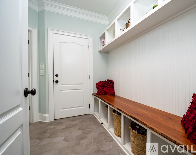 A hallway with a bench and baskets under the shelf.