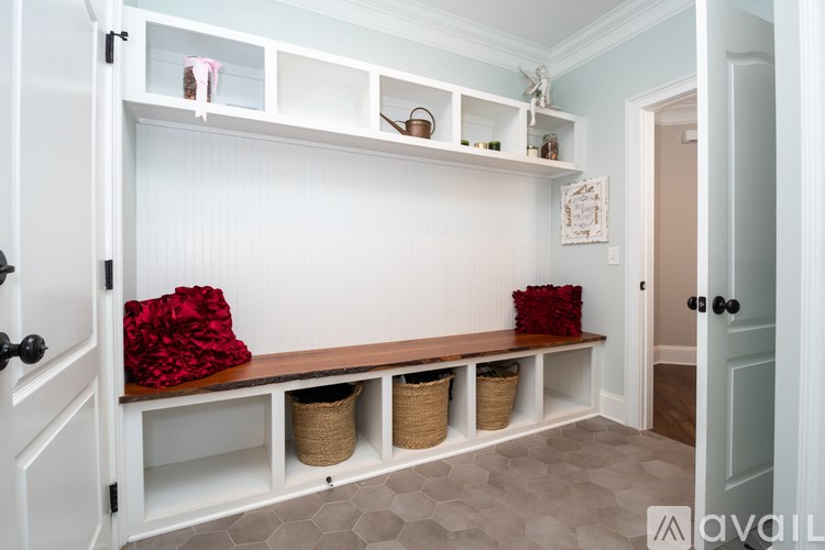A white built-in bench with storage baskets underneath it.