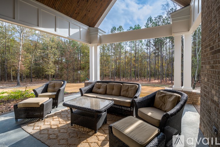 A patio with a couch, chairs and a table.