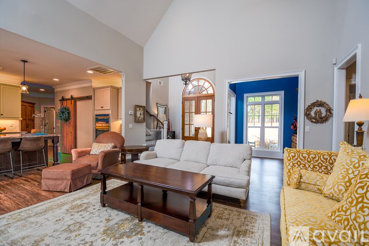 A living room with a white couch and a brown coffee table.