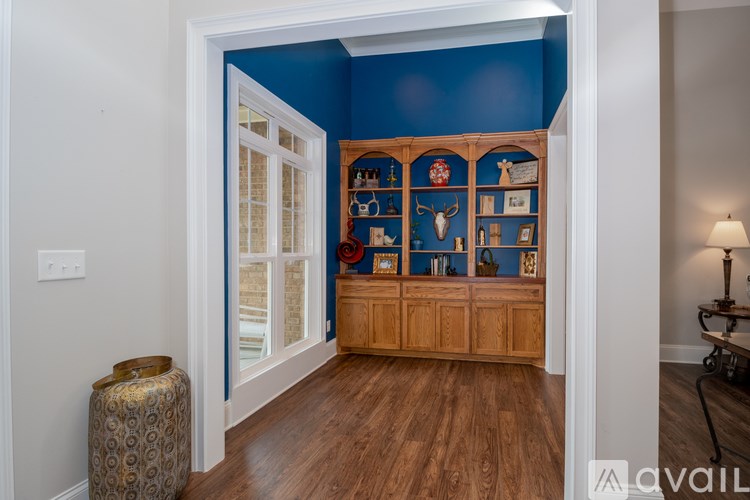 A room with a blue wall and a wooden cabinet with various objects on it.