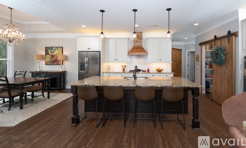 A modern kitchen with a large island and pendant lights.