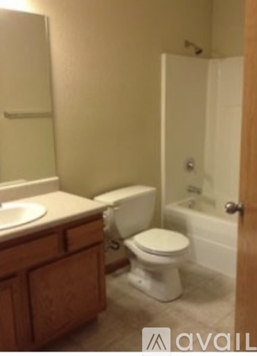 A white toilet sits in a bathroom next to a sink.