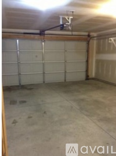 A garage with a white door and a brown floor.