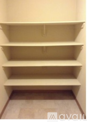 Empty shelves in a room with a wooden floor.