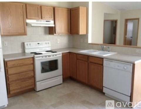 A kitchen with wooden cabinets and white appliances.