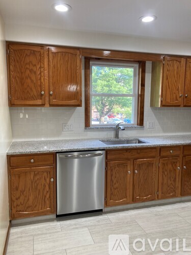 A kitchen with a granite countertop and wooden floors.