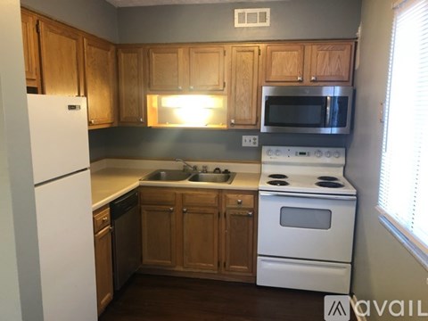 A kitchen with wooden cabinets and white appliances.