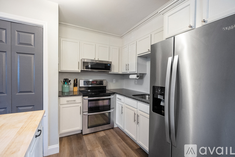 A kitchen with a stainless steel refrigerator and wooden countertops.