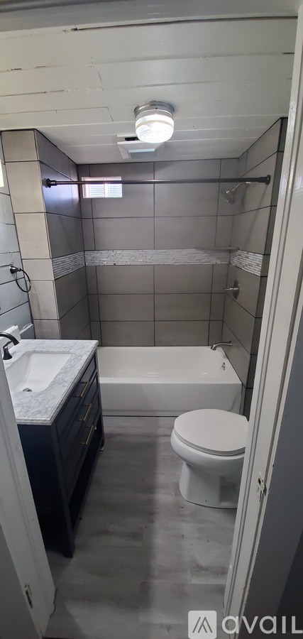 A bathroom with a toilet, sink, and bathtub.