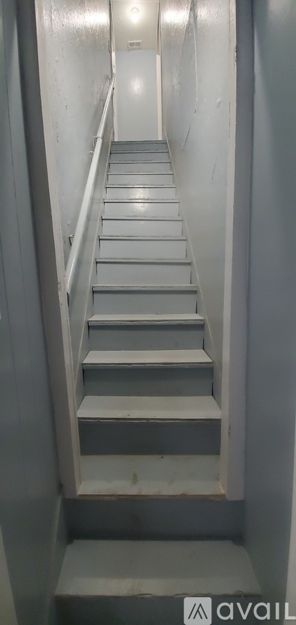 A staircase with a metal railing on the left side.