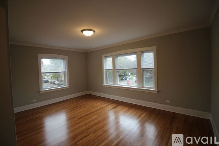 A room with wooden floors and a window on the left side.