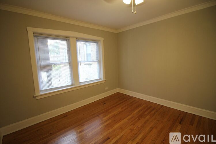 A room with a window and wooden floors is available for rent.