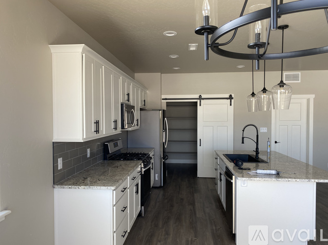 A kitchen with white cabinets and a granite countertop.