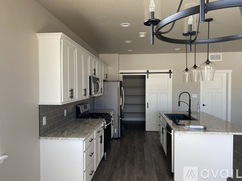 A kitchen with white cabinets and a granite countertop.