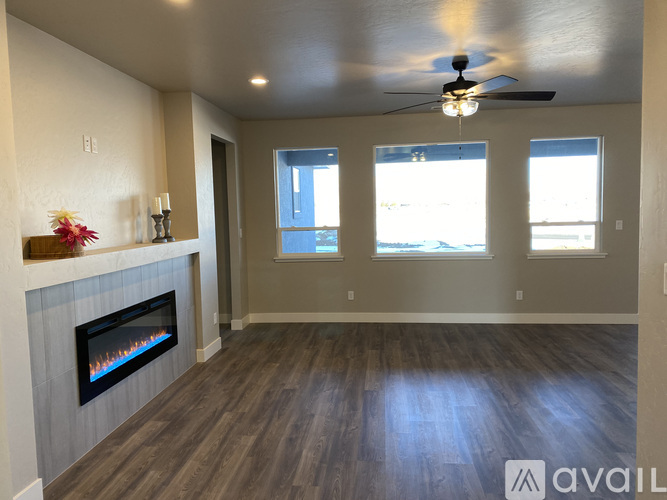 A spacious room with a fireplace and a ceiling fan.