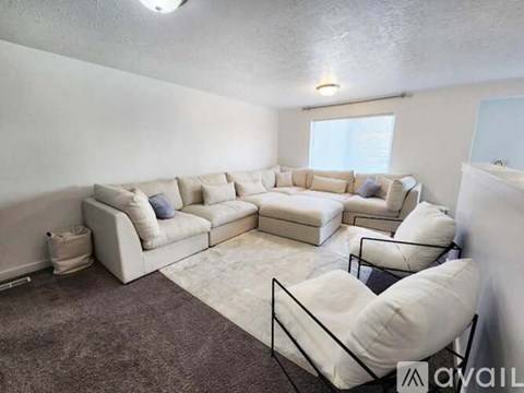 A living room with a white couch and a glass coffee table.