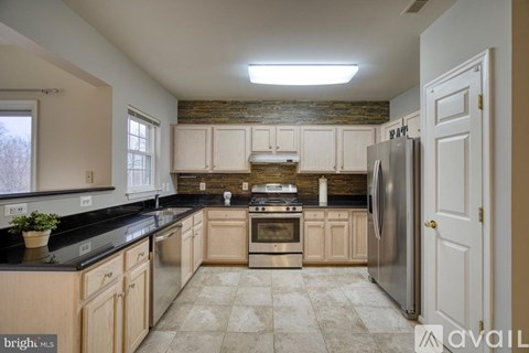 A kitchen with wooden cabinets and a black countertop.
