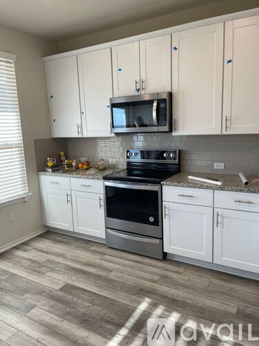 A kitchen with white cabinets and a black stove top oven.