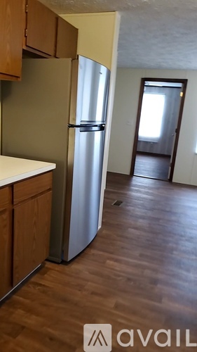 A kitchen with a refrigerator, cabinets and a counter.