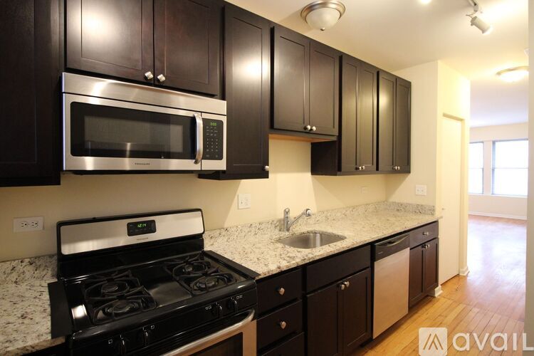 A kitchen with black cabinets and a stainless steel microwave and oven.