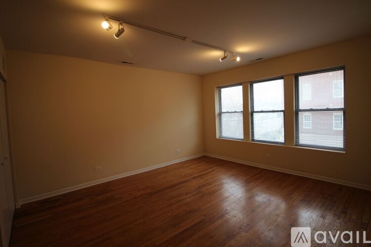 Empty room with wooden floors and windows.