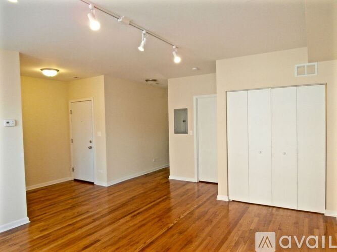 A spacious room with wooden floors and white walls.