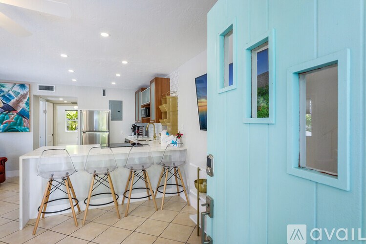 A kitchen with a white table and chairs and a blue wall.